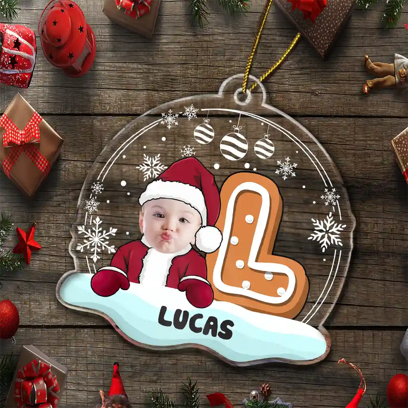 Personalized Christmas ornament with a child's photo and the name 'Lucas' on a wooden background with Christmas decorations.