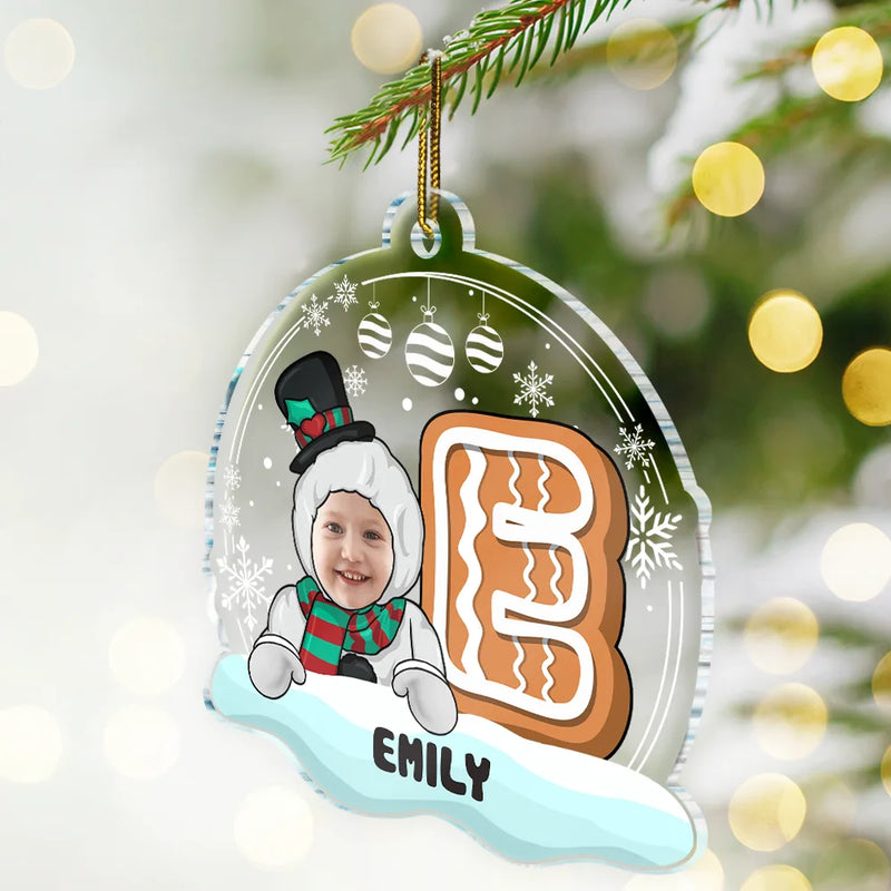 Personalized Christmas ornament with a child's face, gingerbread man design, and name 'EMILY' against a festive background.