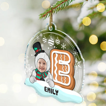 Personalized Christmas ornament with a child's face, gingerbread man design, and name 'EMILY' against a festive background.